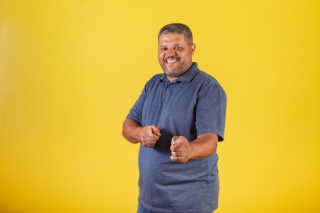 Uomo nero brasiliano adulto sorridente che punta alla telecamera scegliendo te