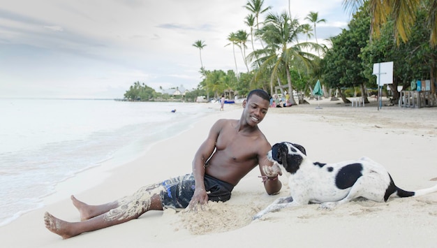 Uomo nero che accarezza cane sulla spiaggia