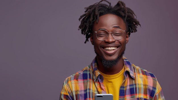 Uomo nero gioioso che legge buone notizie guardando il cellulare con gli occhiali sullo sfondo grigio dello studio