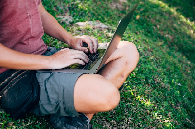 Uomo nomade digitale che lavora nella foresta