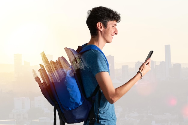 Uomo nomade digitale che viaggia per il mondo lavorando con lo smartphone