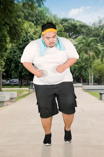 Uomo obeso che fa esercizi di velocità nel parco