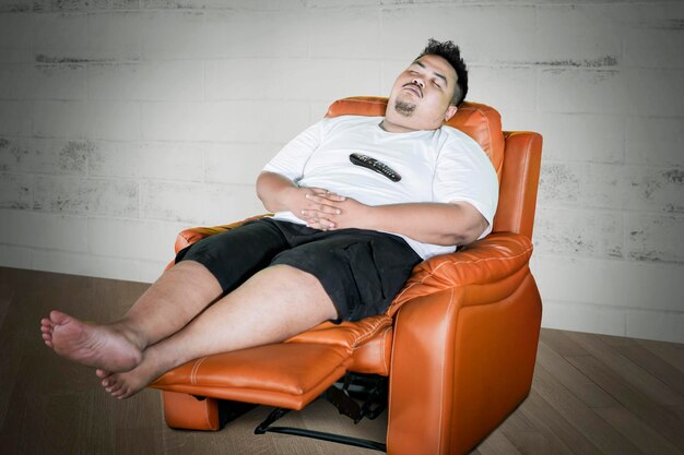 Uomo obeso che si addormenta mentre guarda la TV