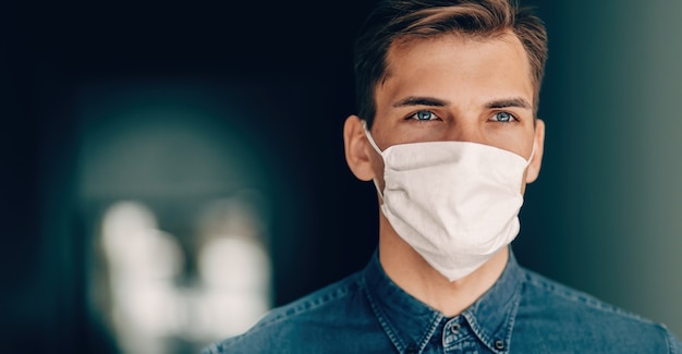 Uomo premuroso in una maschera protettiva che guarda avanti