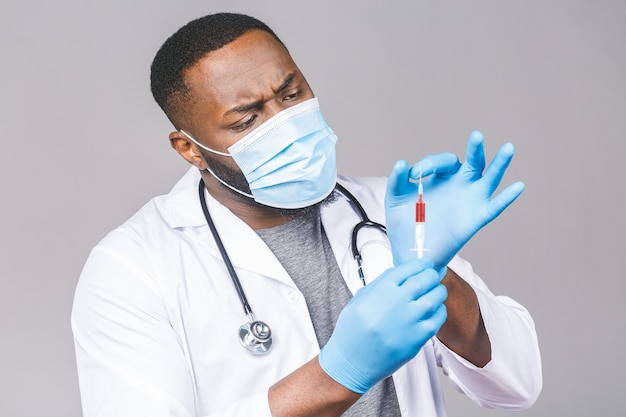 Uomo preoccupato medico afroamericano in guanti maschera viso abito. Tenendo il risultato dell'analisi del sangue.