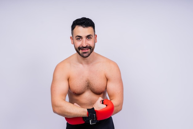 Uomo pugile con guanti rossi da boxe sportivo nello spazio di copia dello studio