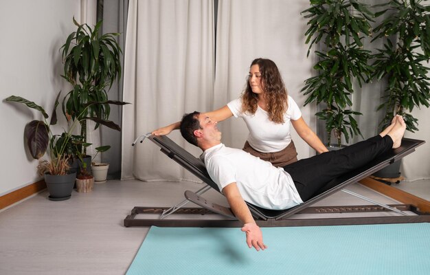 Uomo rilassato che impara le pose dello yoga con l'insegnante