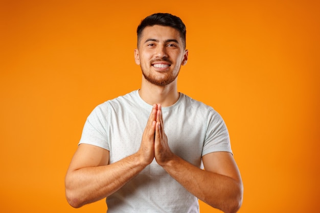 Uomo rilassato in piedi nella meditazione posa su sfondo giallo