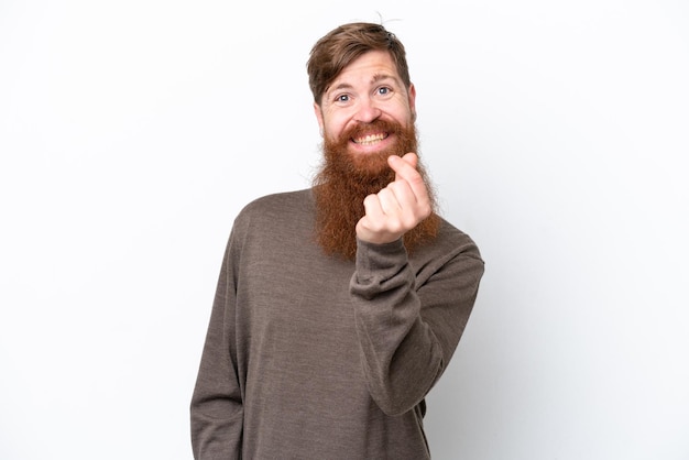 Uomo rosso con la barba isolato su sfondo bianco che fa gesto di denaro