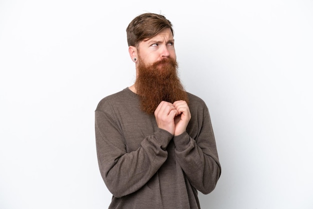 Uomo rosso con la barba isolato su sfondo bianco che trama qualcosa