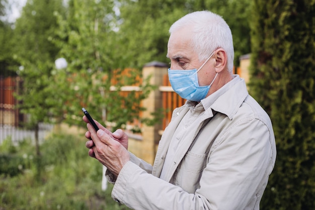 Uomo scioccato con mascherina medica usando il telefono per cercare notizie