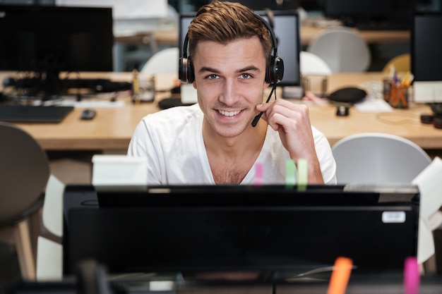 Uomo seduto accanto al computer in cuffia