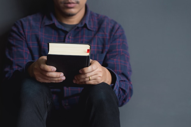 Uomo seduto e in possesso di una Bibbia. Bibbia, preghiera, uomini.