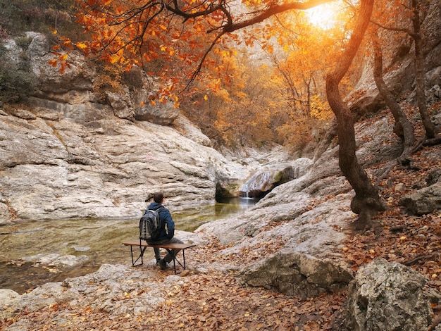 Uomo seduto sul canyon d'autunno