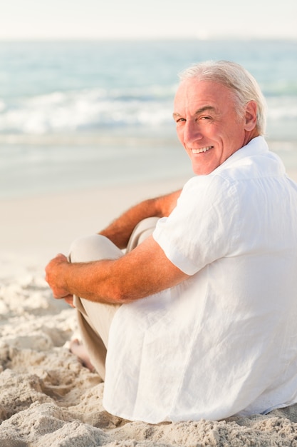 Uomo seduto sulla spiaggia