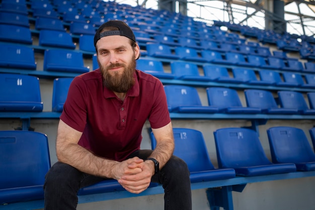 Uomo seduto sulla tribuna vista frontale