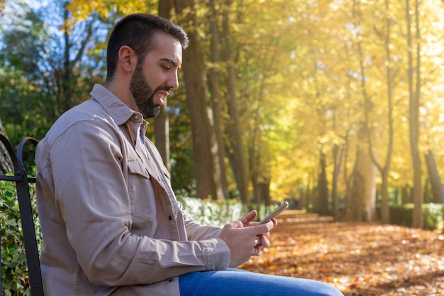 Uomo seduto utilizzando il suo smartphone