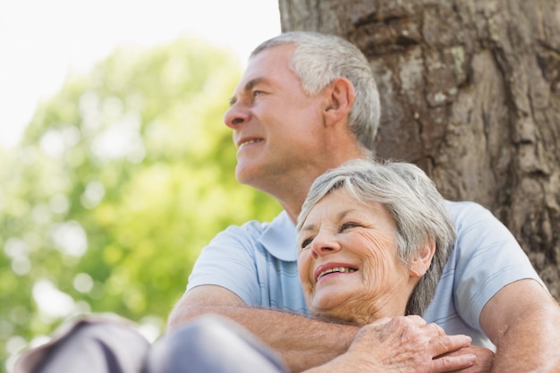 Uomo senior che abbraccia donna da dietro al parco