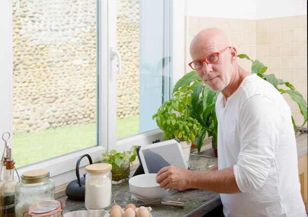 Uomo senior che cucina nella cucina a casa