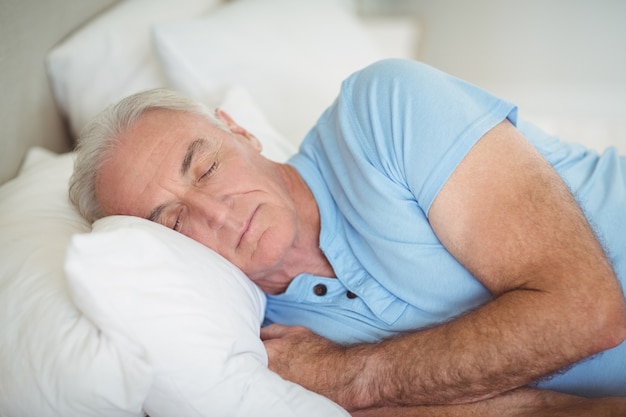 Uomo senior che dorme sul letto