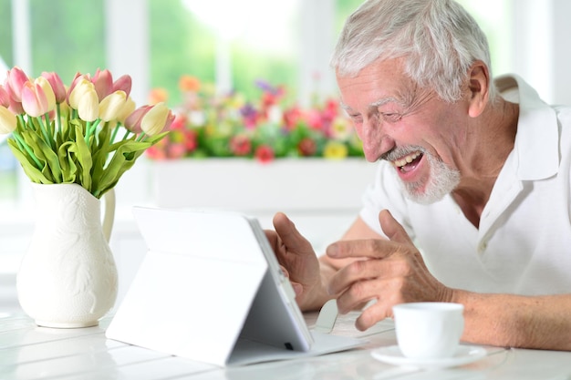 Uomo senior che per mezzo del computer portatile a casa