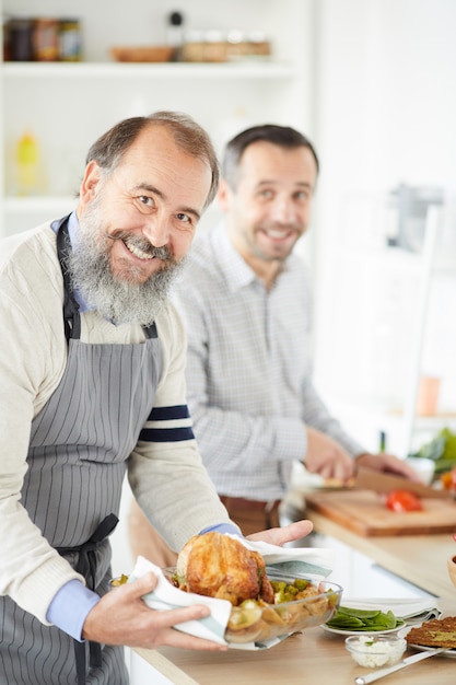 Uomo senior che prepara tacchino a casa