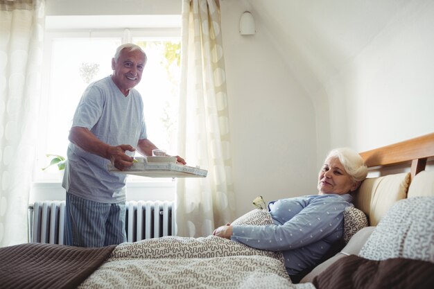 Uomo senior che serve la colazione alla donna senior