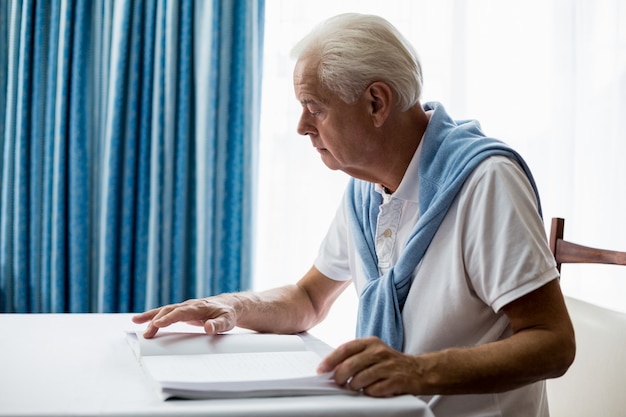 Uomo senior che usando il Braille per leggere