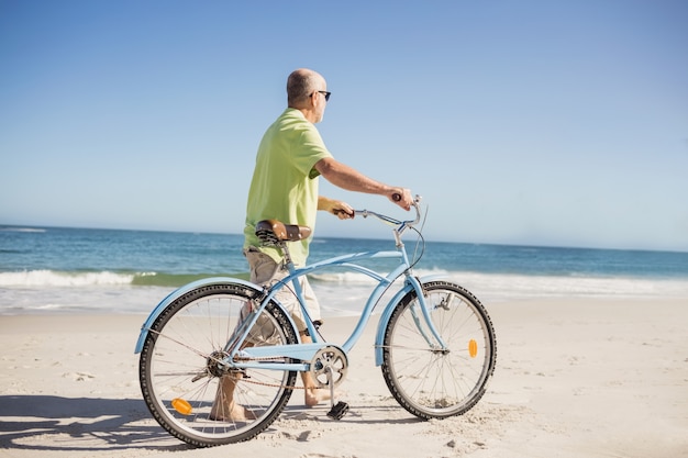 Uomo senior sorridente con la bici