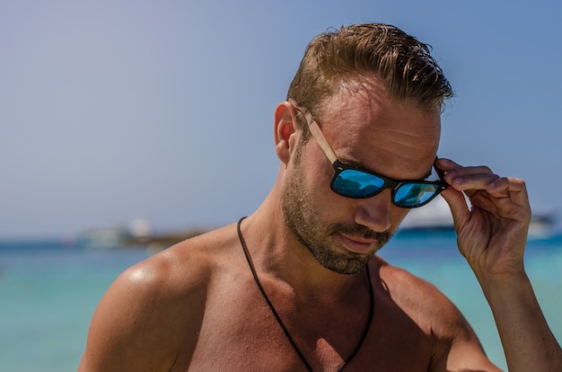 Uomo senza camicia che gode della spiaggia