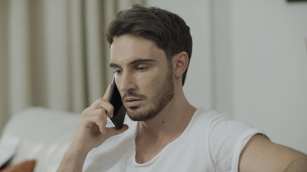 Uomo serio che parla al telefono cellulare a casa Uomo d'affari preoccupato chiama il telefono