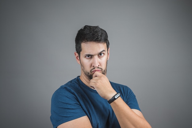 Uomo serio con sguardo intenso, guardando e alzando un sopracciglio