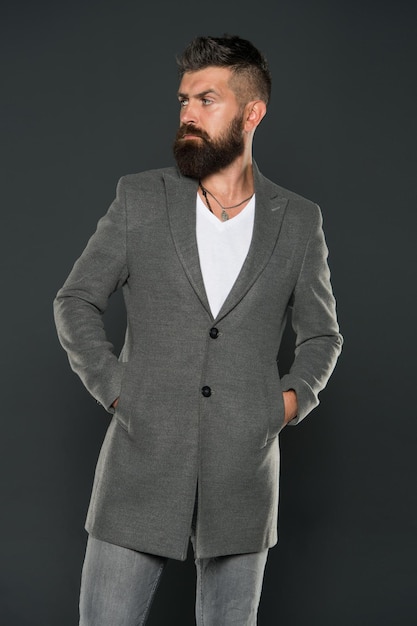 Uomo serio concentrato. Uomo caucasico con aspetto brutale. Uomo barbuto con baffi e barba sul viso non rasato in stile brutale. Brutale hipster che indossa abiti casual. Cappotto semplice e comodo.