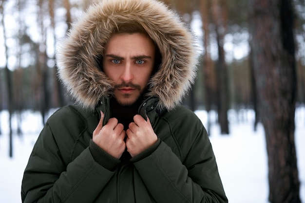 Uomo serio nella foresta invernale