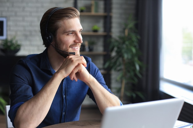 Uomo sicuro che indossa l'auricolare che parla e guarda la formazione sul webinar aziendale, ascoltando la lezione.