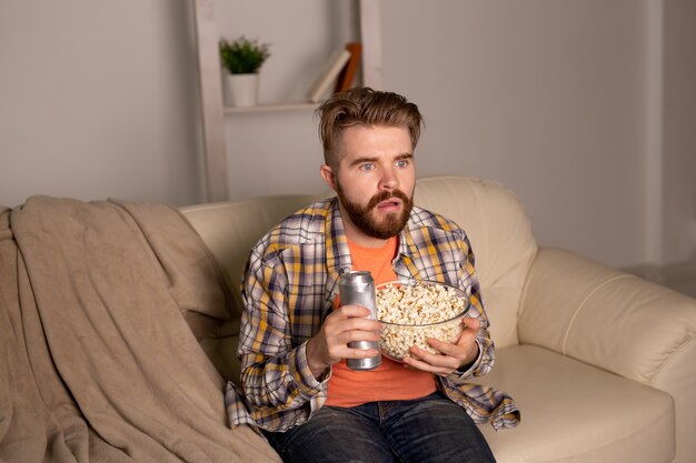 Uomo single sul divano che guarda la tv