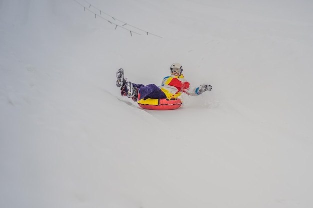 Uomo snow tubing dal concetto di attività invernale in collina