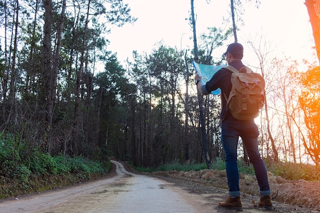 Uomo solitario che indossa jeans e stivali di pelle che camminano lungo il sentiero cosparso di rocce.