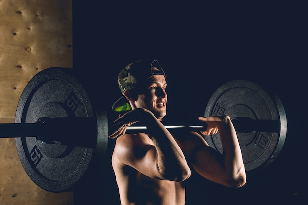 Uomo sollevamento pesi. allenamento uomo muscoloso in palestra facendo esercizi con bilanciere