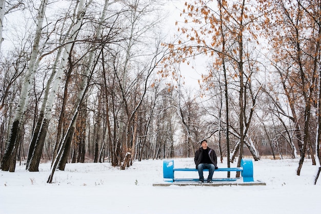 Uomo solo sulla panchina in un parco invernale