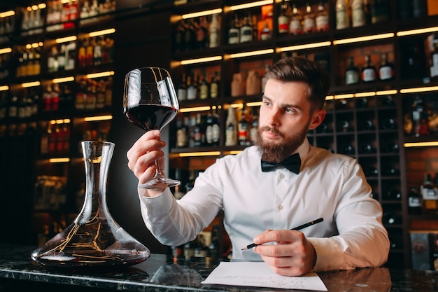 uomo sommelier degustazione vino rosso in cantina