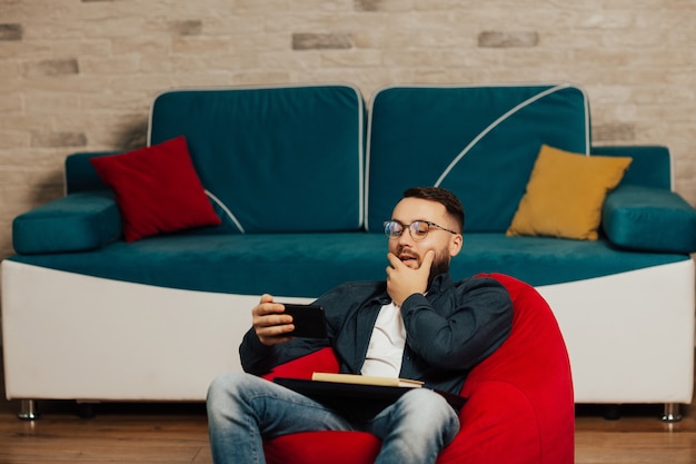 Uomo sorpreso che tiene il telefono e legge buone notizie. Uomo con lo smartphone di essere sorpreso come leggere il messaggio.