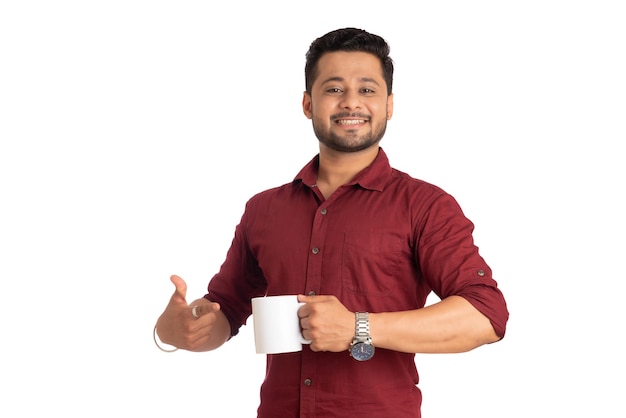 Uomo sorridente bello con una tazza di caffè o tè isolato su priorità bassa bianca
