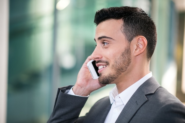 Uomo sorridente che comunica sul telefono cellulare