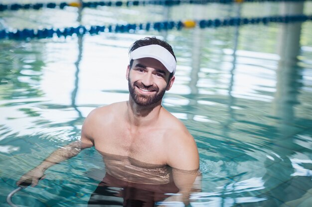 Uomo sorridente che fa bici subacquea in piscina