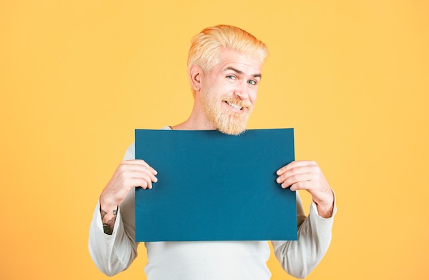 Uomo sorridente che mostra una lavagna bianca che pubblicizza un uomo felice di mezza età che presenta un foglio vuoto per