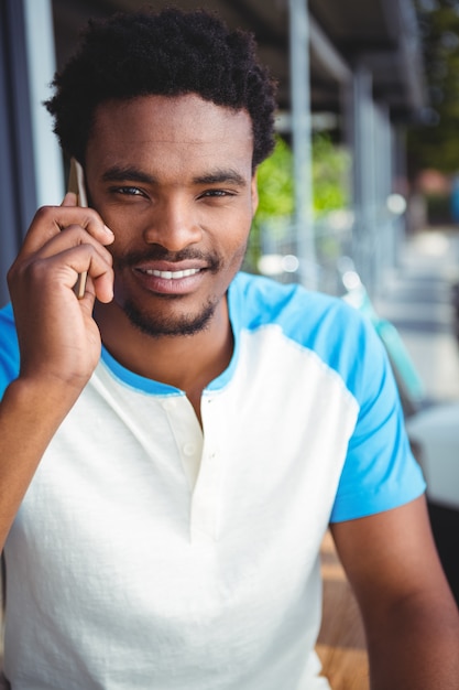 Uomo sorridente che parla sul telefono cellulare