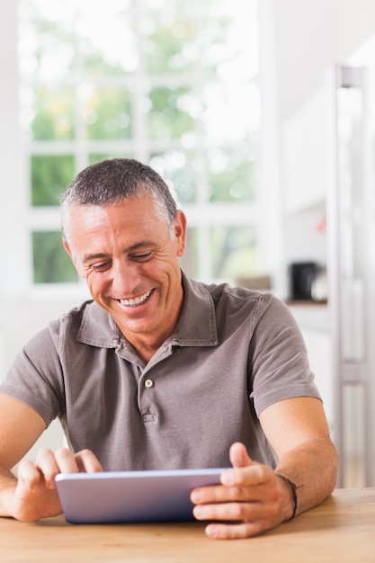 Uomo sorridente che per mezzo del ridurre in pani