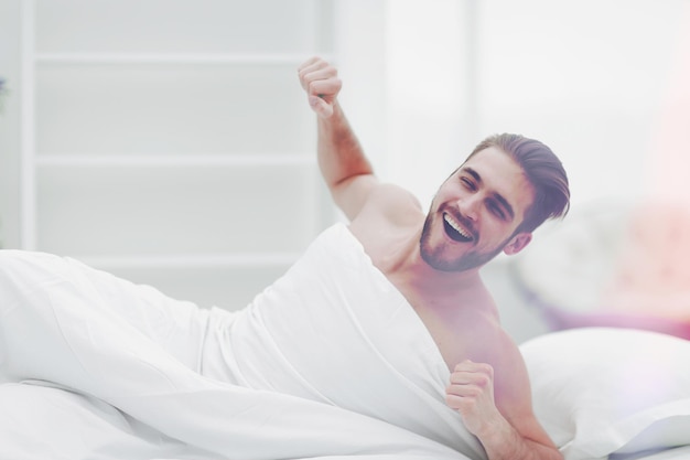 Uomo sorridente che si sveglia al mattino