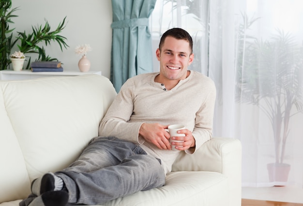 Uomo sorridente che tiene una tazza di caffè